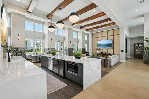 A modern kitchen with a marble countertop and stainless steel appliances.