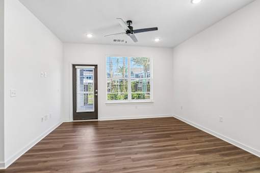 Empty living room with wood flooring and ceiling fan at Velara Luxury Apartments, Ponte Vedra Beach, 32081