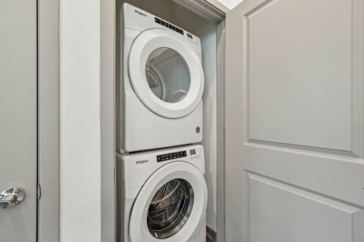 A white washing machine is in a cabinet. at The Sophia, Venice, FL