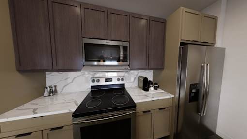 A kitchen with a stove, microwave, and refrigerator.at Terrassa Luxury Apartments, Saint Augustine