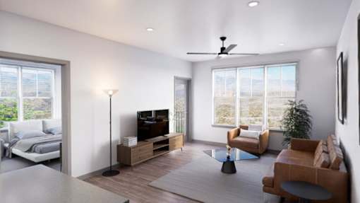 A modern living room with a television, a couch, a chair, and a potted plant at Refinery at Pointe17 Apartments, Phoenix, AZ
