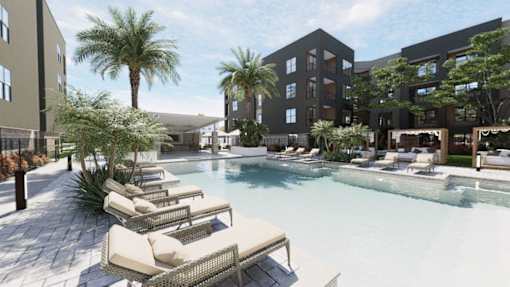 A pool surrounded by lounge chairs and palm trees at Refinery at Pointe17 Apartments, Phoenix, AZ