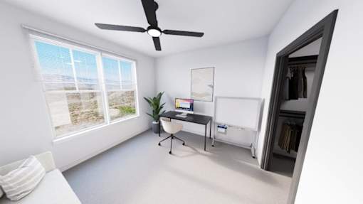 A room with a ceiling fan, a bed, and a window overlooking the beach at Refinery at Pointe17 Apartments, Arizona, 85085