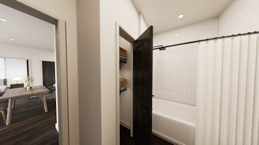 A black door is open to a bathroom with a white tub.