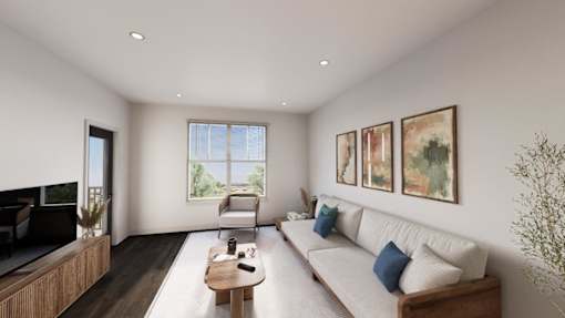 A living room with a white couch, a wooden coffee table, and three framed pictures on the wall.