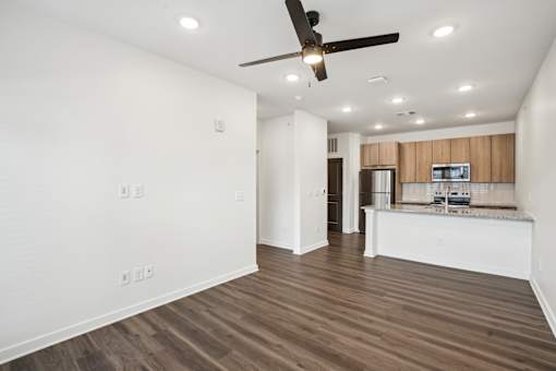 A room with a ceiling fan and wooden flooring. at The Pullman Luxury Apartments, Georgia, 30349