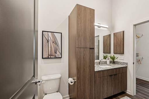 A bathroom with a toilet, sink, and mirror at The Stadler Luxury Apartments, Florida 34210