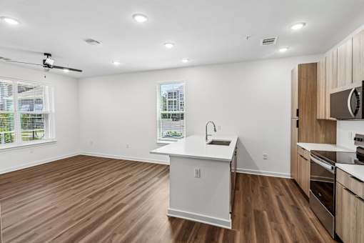 Open concept kitchen with island and wood style flooring at Velara Luxury Apartments, Florida