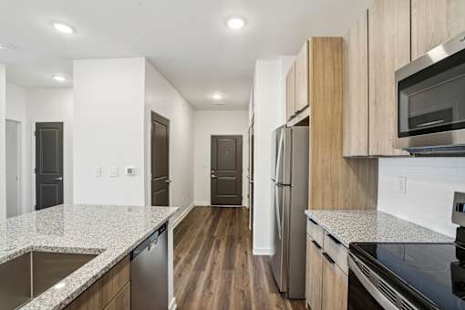 A kitchen with a refrigerator, microwave, and oven. at The Pullman Luxury Apartments, Georgia, 30349