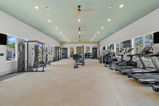 A spacious gym with treadmills and elliptical machines.
