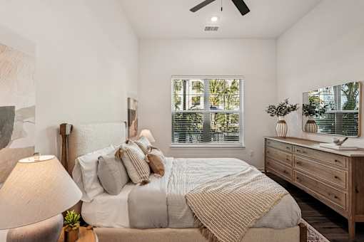 A bedroom with a bed, nightstand, and window at The Stadler Luxury Apartments, Bradenton, 34210