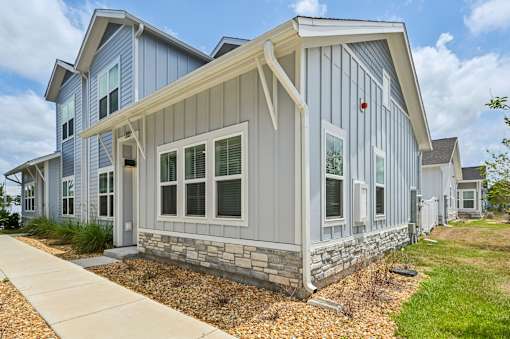 A modern house with a grey and white exterior and a stone foundation. at The Sophia, Venice, FL