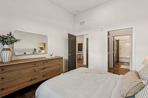 A bedroom with a bed, dresser, and mirror at The Stadler Luxury Apartments, Florida