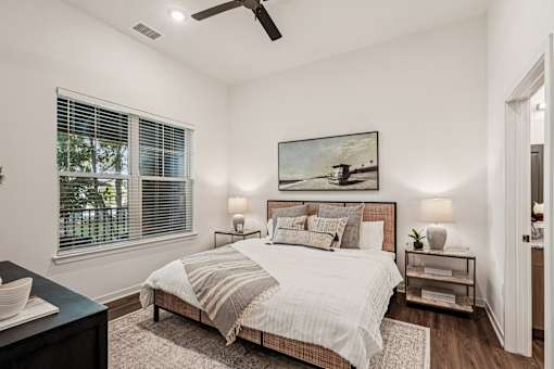 A bedroom with a bed, nightstands, and a painting on the wall at The Stadler Luxury Apartments, Bradenton, FL