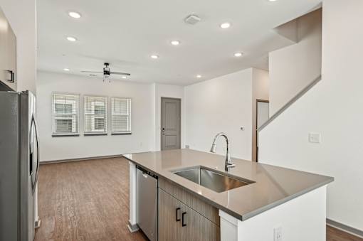 A modern kitchen with a stainless steel sink and refrigerator. at The Sophia, Venice, FL