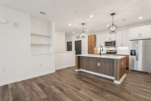 A kitchen with a wooden island and stainless steel appliances.