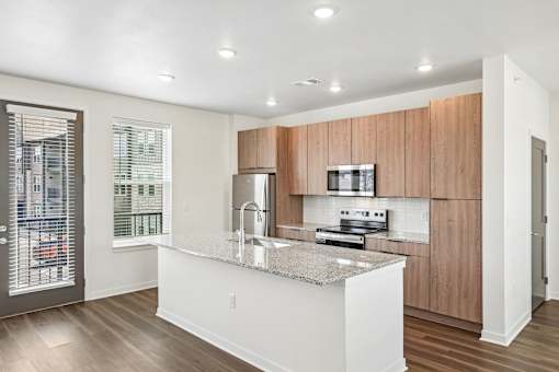 A modern kitchen with wooden cabinets and a granite countertop.