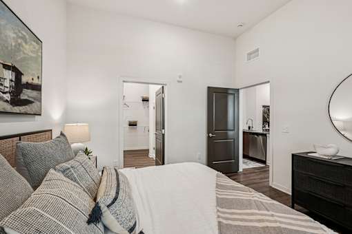 A bedroom with a bed, dresser, and mirror at The Stadler Luxury Apartments, Bradenton, FL 34210