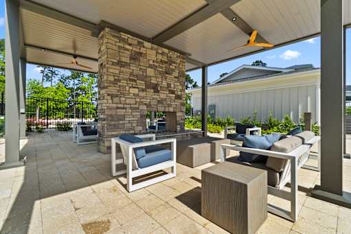 A patio with a stone pillar and a white couch.