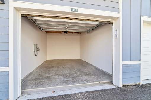 Single car garage with concrete floor and storage at Velara Luxury Apartments, Ponte Vedra Beach, Florida