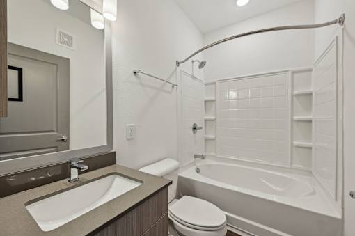 A white bathroom with a toilet, sink, and bathtub. at The Sophia, Venice, FL