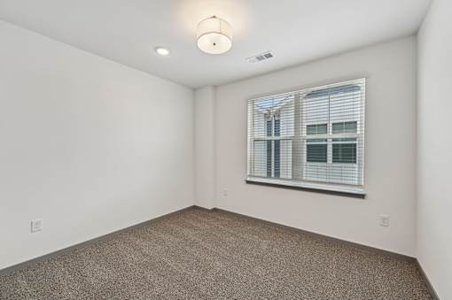 A room with a window and a carpeted floor. at The Sophia, Venice, FL