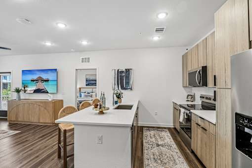 Kitchen island with white countertop and bar seating at Velara Luxury Apartments, Ponte Vedra Beach, FL