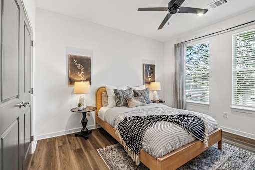 Bedroom with wood bed frame and ceiling fan at Velara Luxury Apartments, Ponte Vedra Beach, Florida
