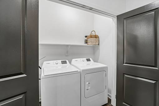 Laundry nook with white washer and dryer at Velara Luxury Apartments, Florida