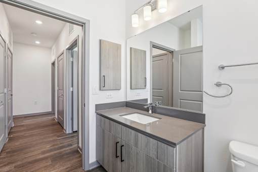 A bathroom with a sink, mirror, and toilet.