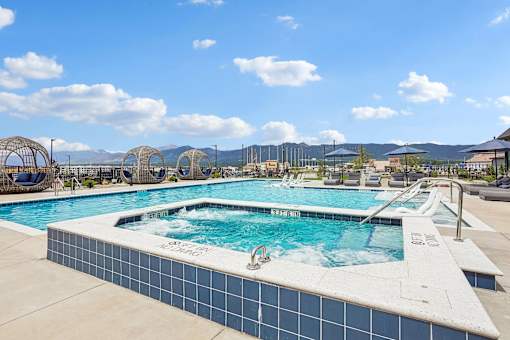 A large outdoor swimming pool with a blue tiled edge and a white tile edge.