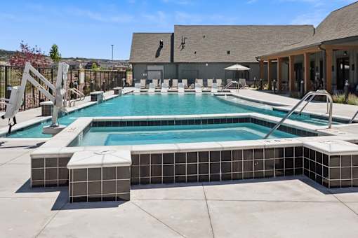 A large outdoor swimming pool with a slide and sun loungers.