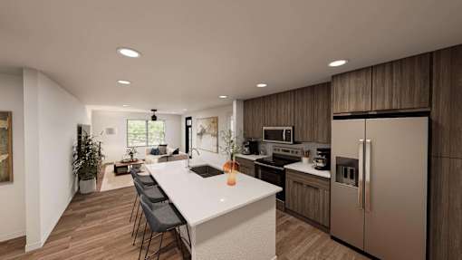 A modern kitchen with a long white island and stainless steel appliances.
