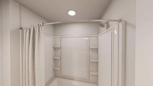A white bathroom with a shower curtain and a shower head.