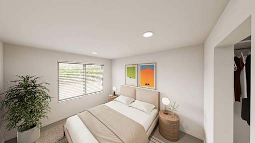 A bedroom with a bed, nightstand, and a potted plant.