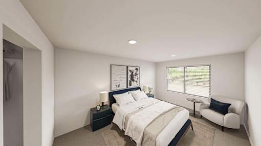 A bedroom with a large bed, a chair, and a nightstand with a lamp.
