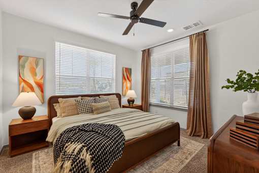 A bedroom with a bed, nightstands, and a ceiling fan.at Refinery at Pointe17 Apartments, Phoenix, AZ, 85085