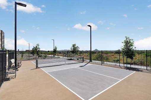 A tennis court with a net and a fence surrounding it.at Refinery at Pointe17 Apartments, Phoenix, AZ, 85085