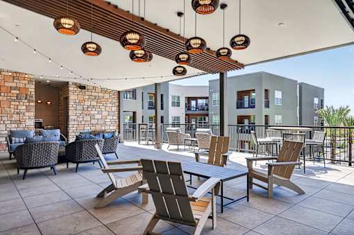 A patio with a table and chairs under a wooden beam.at Refinery at Pointe17 Apartments, Phoenix, AZ, 85085