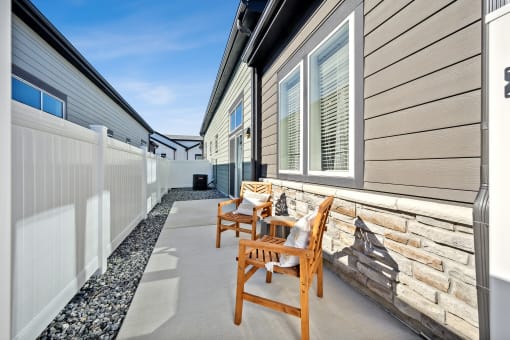 a patio with two chairs and a wall with a fence at Citadel at Castle Pines, Castle Pines, 80108