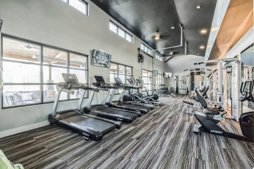 the gym with cardio equipment and windows at Citadel at Castle Pines, Castle Pines, Colorado