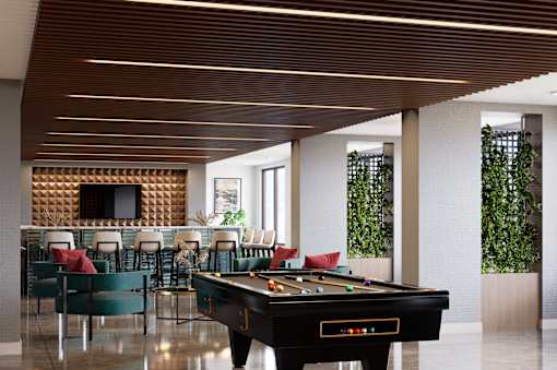 A pool table is in the middle of a room with a tv and chairs at Refinery at Pointe17 Apartments, Phoenix