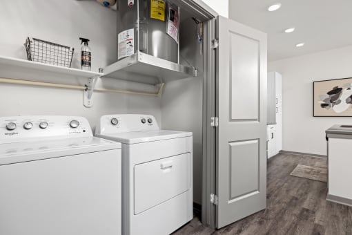 a white washer and dryer in a room with a refrigerator and a door at The Depot in The Depot Raymore, MO 64083