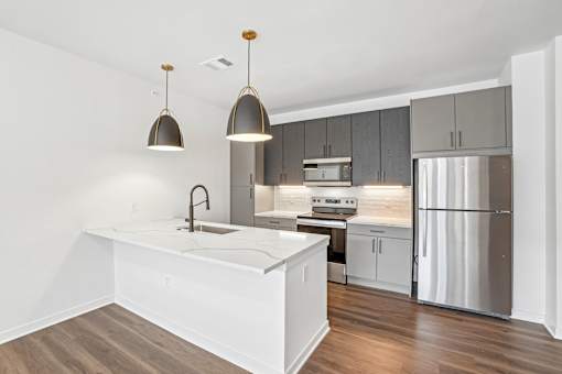 A modern kitchen with a white island and stainless steel appliances.