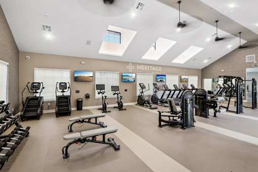 A gym with a variety of equipment including treadmills, exercise bikes, and weight machines.