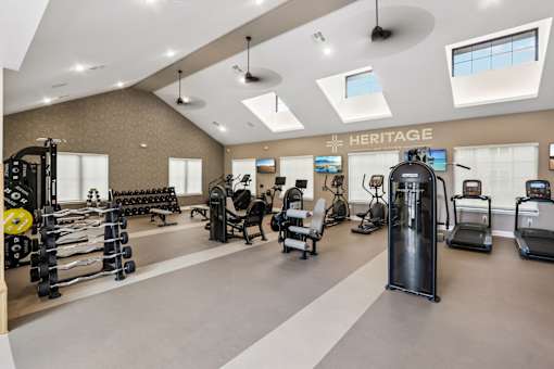A gym with a variety of equipment including treadmills, weights, and exercise machines.