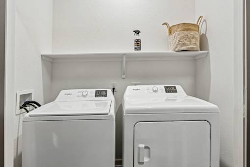 A white washing machine and dryer in a small laundry room.