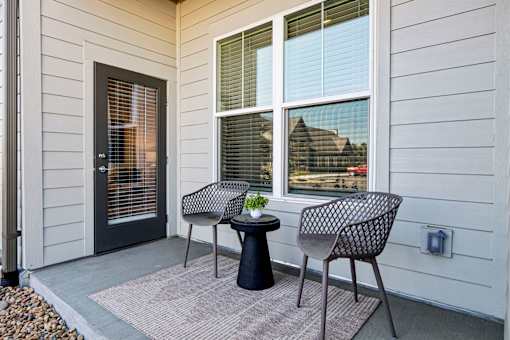 A patio with a table and two chairs.
