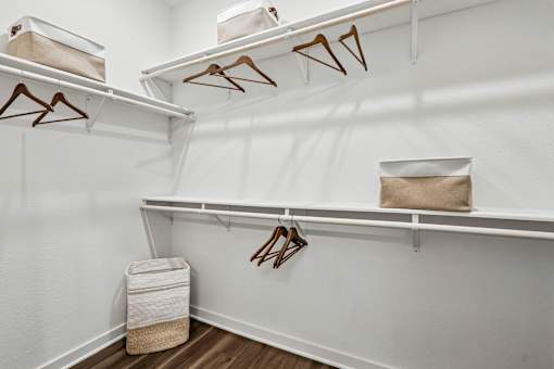 Closet with white shelves and hangers.