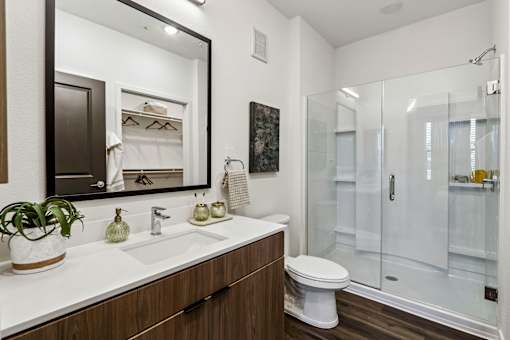 A bathroom with a white sink and a large mirror.